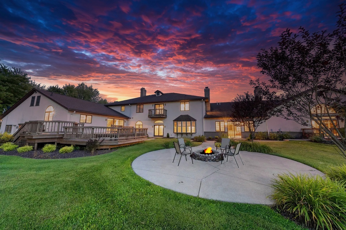 Enjoy the view of the house with a picturesque sky and inviting fire pit.