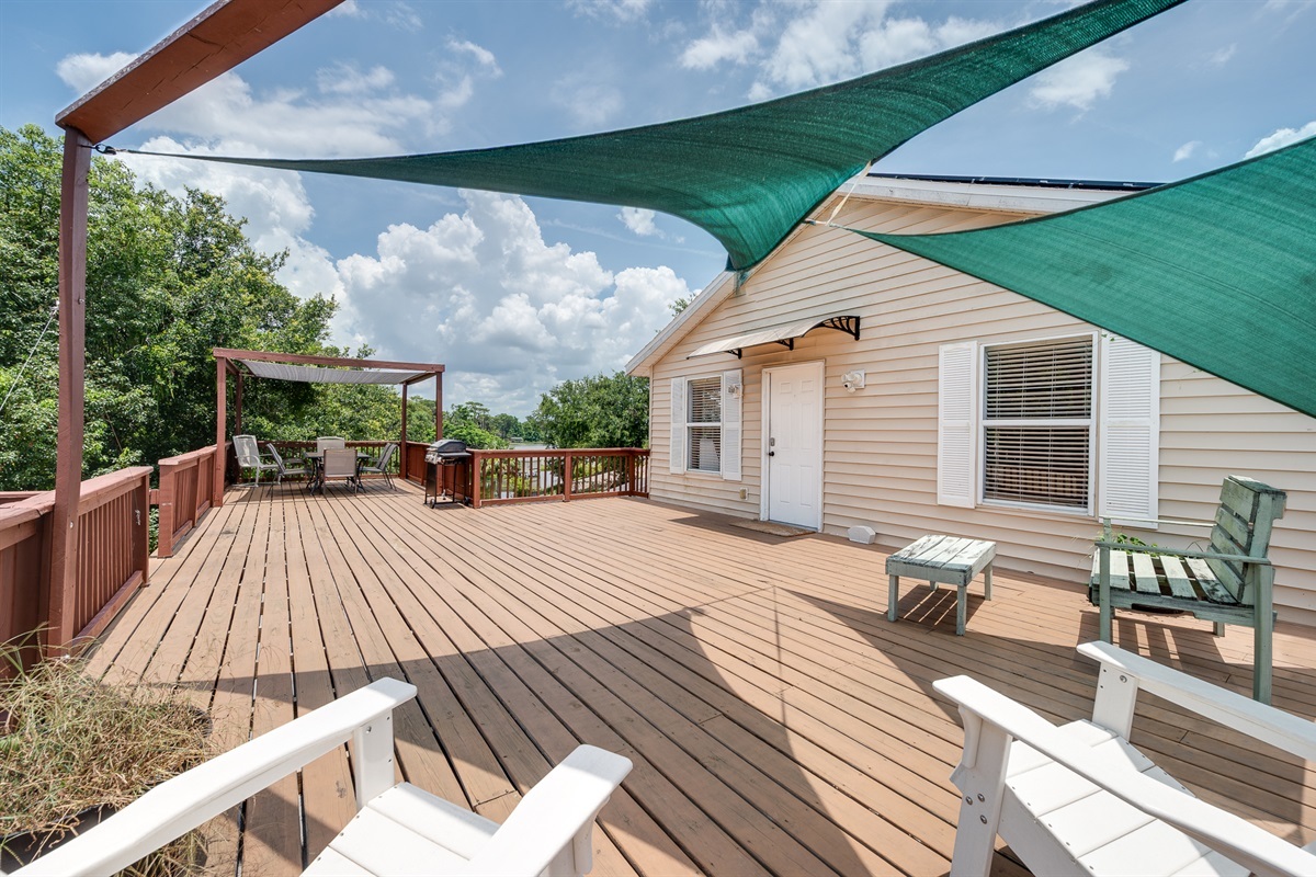 Outdoor patio, pergola, and grill with a stunning lake view