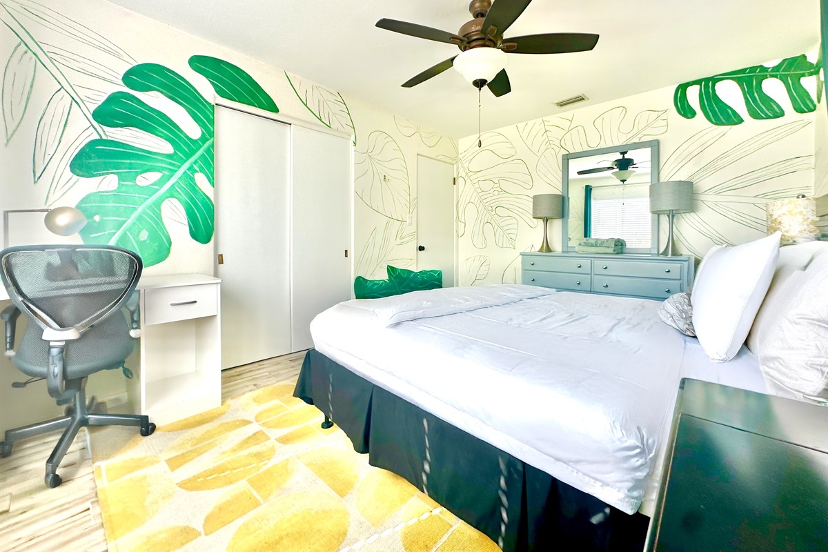 Tropical bedroom with a queen bed and workspace for your comfort.