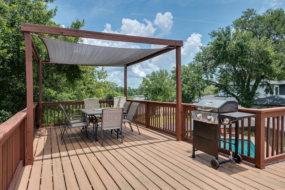 Outdoor patio, pergola, and grill with a stunning lake view