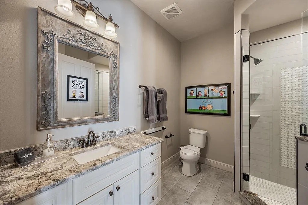 Elegant full bathroom with granite counters and a spacious walk-in shower