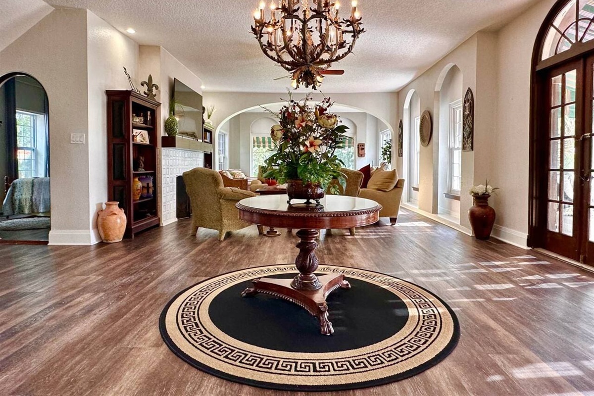 Gather beneath the grand chandelier in this elegant living room, ideal for weddings and luxury stays.