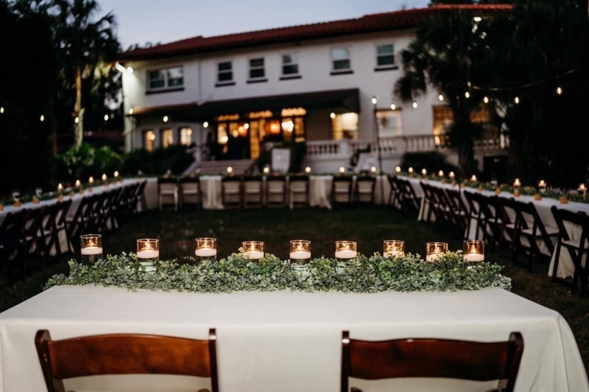 Host an elegant outdoor wedding reception with string lights, long tables, and romantic garden views.