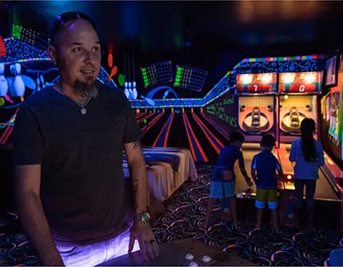Guest posing in front of glow-in-the-dark bowling alley at Lake Louisa Chateau