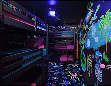 Mini Golf Glow Room with neon blacklight murals and bunk beds at Lake Louisa Chateau, Clermont FL