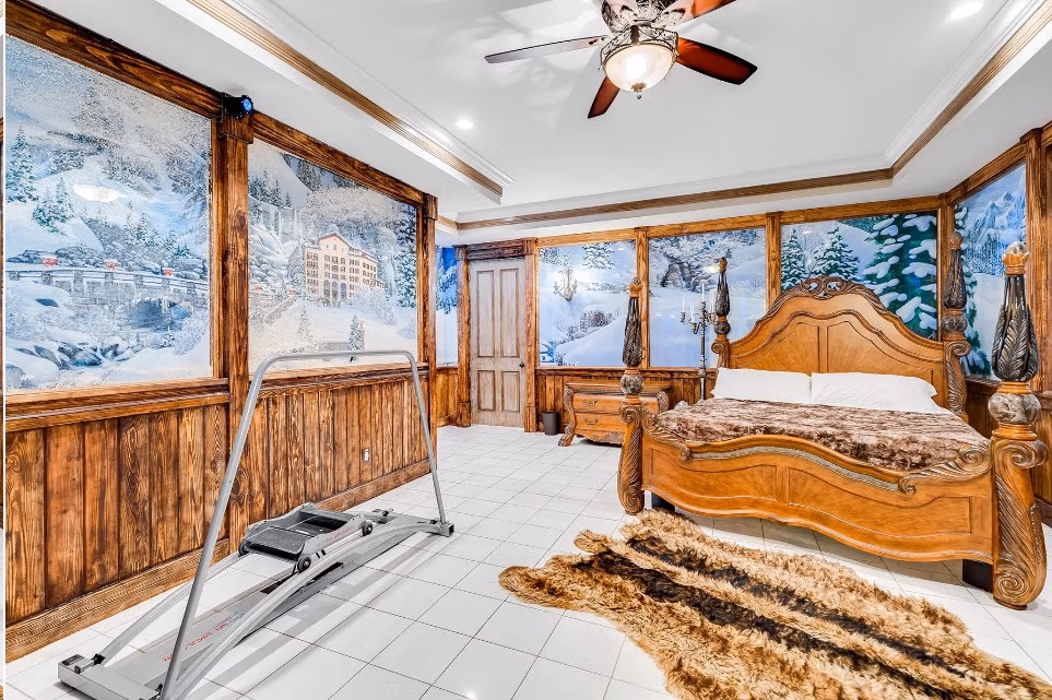 Ski Lodge Bedroom with alpine mural, carved wood king bed, and ski machine at Lake Louisa Chateau