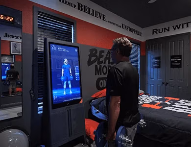 Guest using interactive workout TV screen in Iron Man Gym Bedroom at Lake Louisa Chateau
