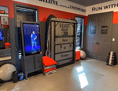 Home gym with motivational wall text, workout TV screen, and dumbbells in Iron Man Gym Bedroom at Lake Louisa Chateau