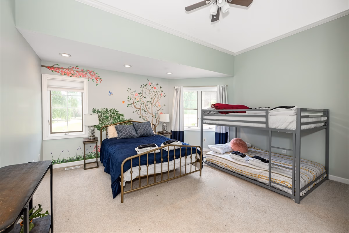 Bedroom with queen bed, bunk bed, and floral wall mural in Cleveland Room at Medina Mansion, Ohio