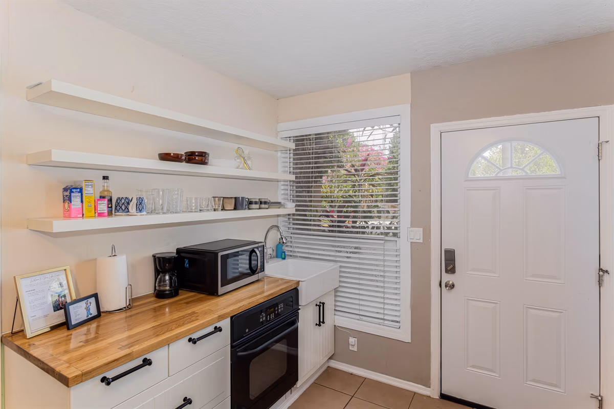 Guest house kitchenette with open shelving and butcher block counter in Blue Room at Clear Lake Casa
