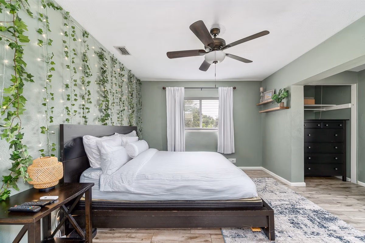 King bedroom with ivy vine wall and fairy lights in Downstairs Tropic Room at Jessamine Dream, Florida